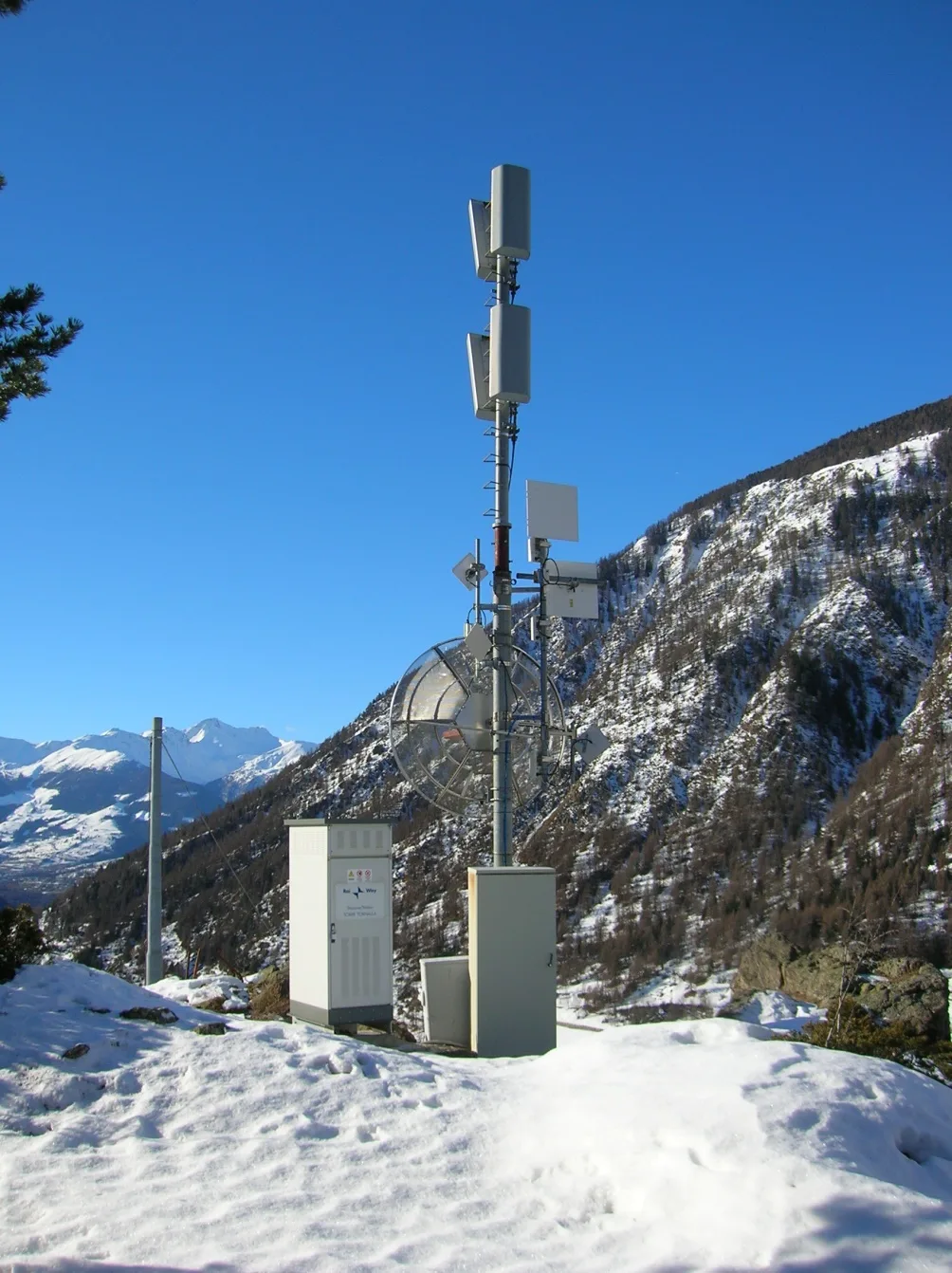 Stazione di trasmissione su traliccio in montagna, con la neve